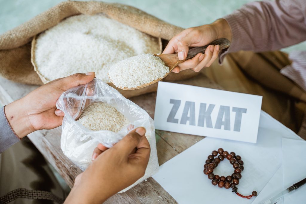 hands-giving-rice-grains-zakat-helping-poor-min