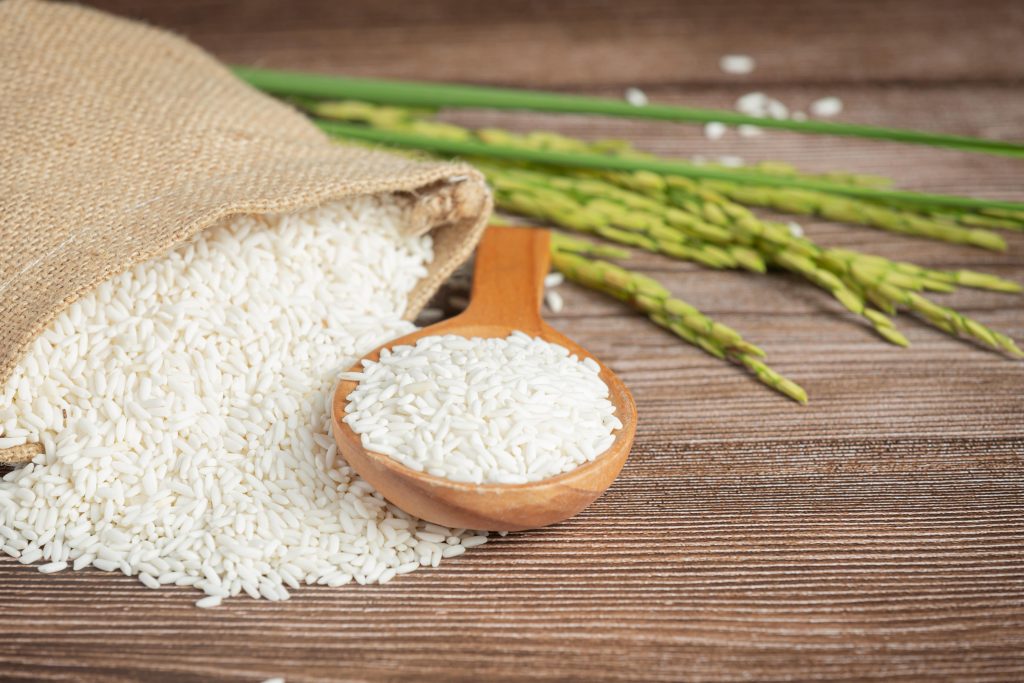sack-rice-with-rice-wooden-spoon-rice-plant-min
